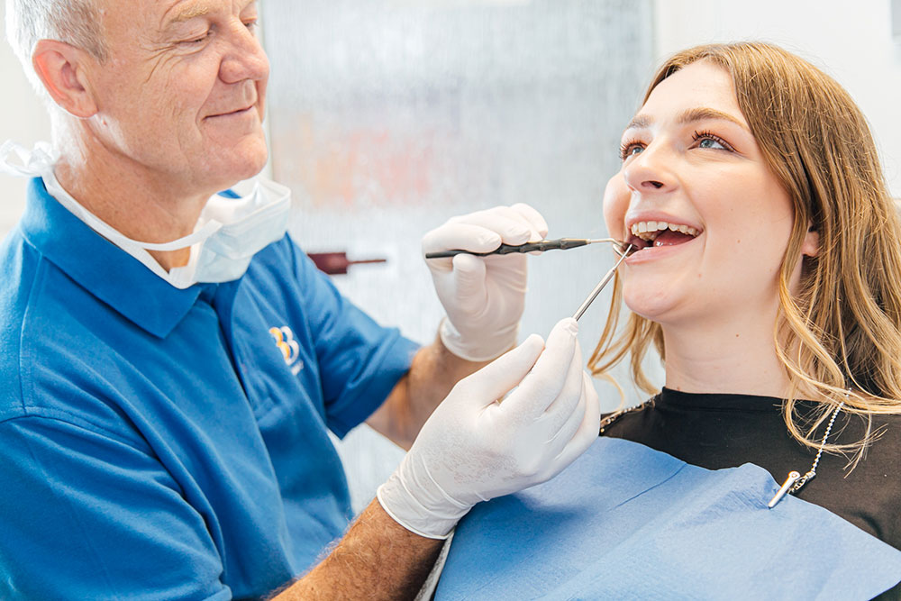 Zahnarzt Köln Innenstadt - Dr. Bongartz kontrolliert die Zähne einer jungen Patientin